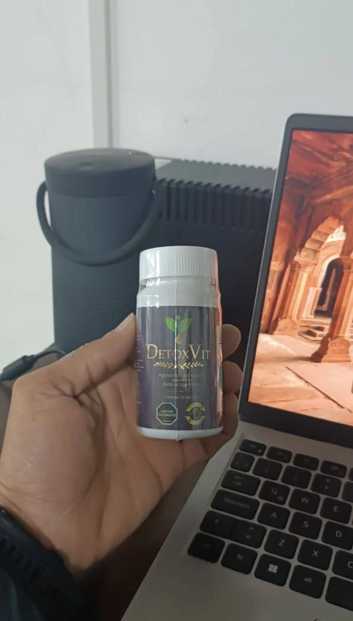 Frasco original de DetoxVit en la mano: etiqueta morada y letras doradas